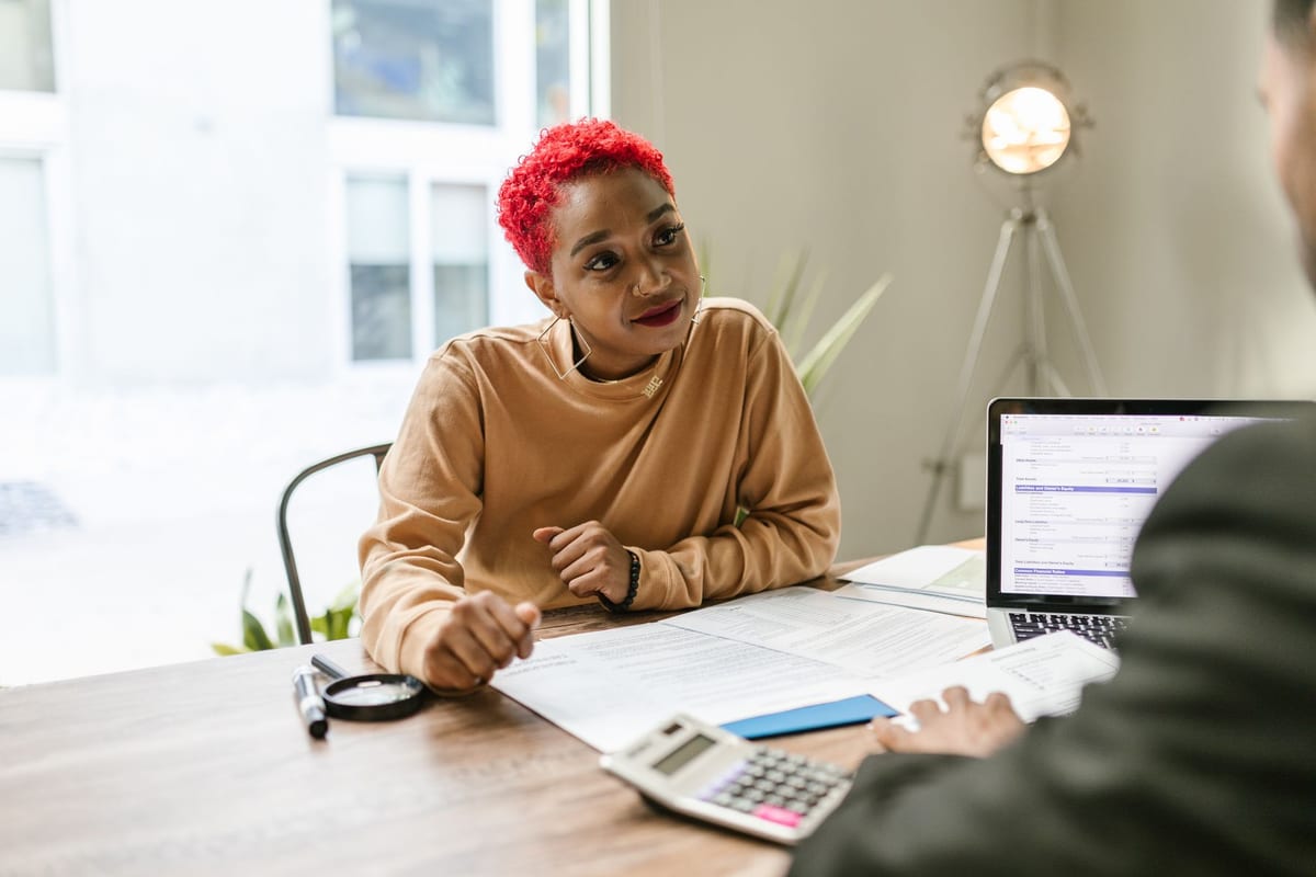 A client and advisor reviewing spreadsheets together at a table