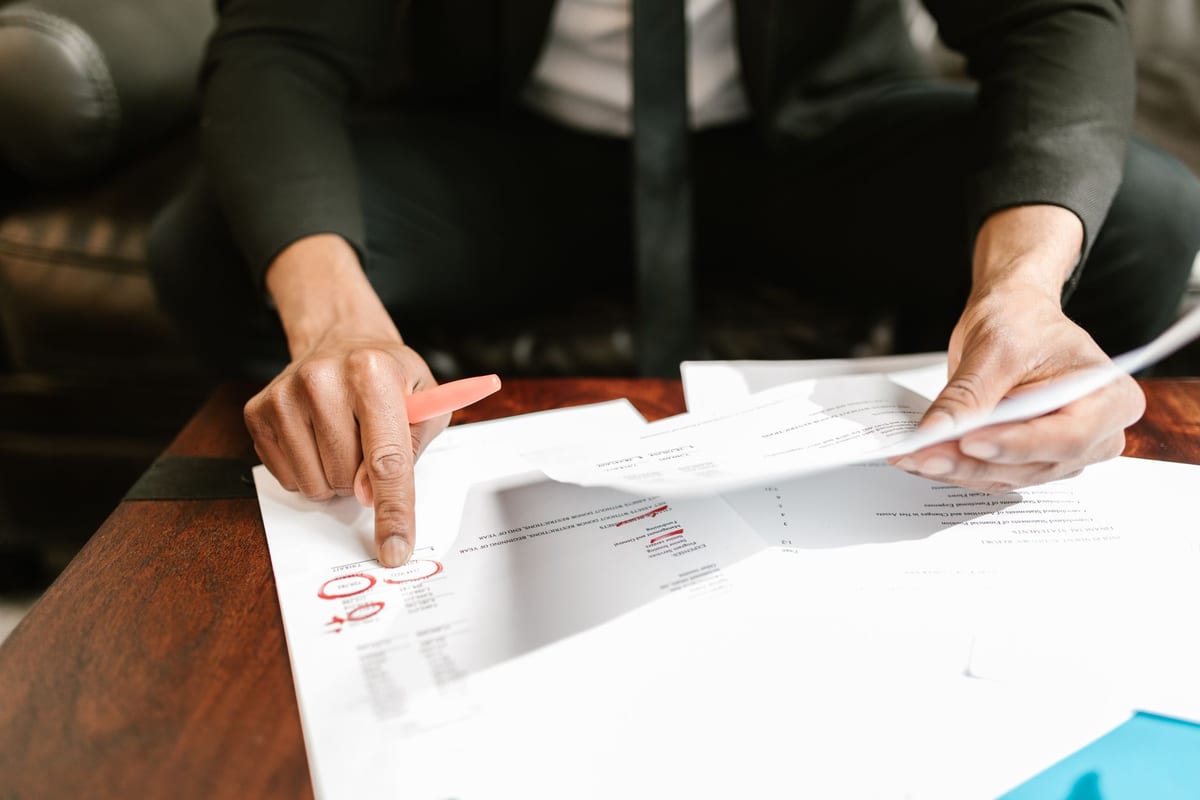 Close detail of a hand pointing out a line on a financial document